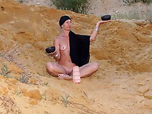On sand seminude with light-color vase